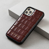 Burgundy crocodile-patterned phone case on a light gray surface