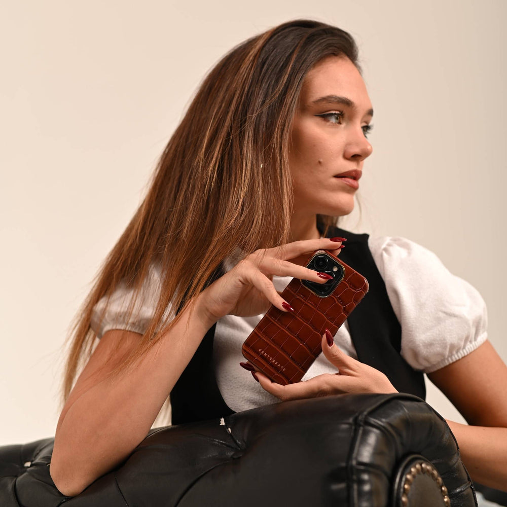 Leather iPhone Case Crocodile Pattern A girl is holding a brown crocodile iPhone 16 Pro case from the brand Gentcreate.