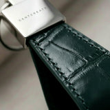 Dark green crocodile leather keychain extreme close up of leather grain