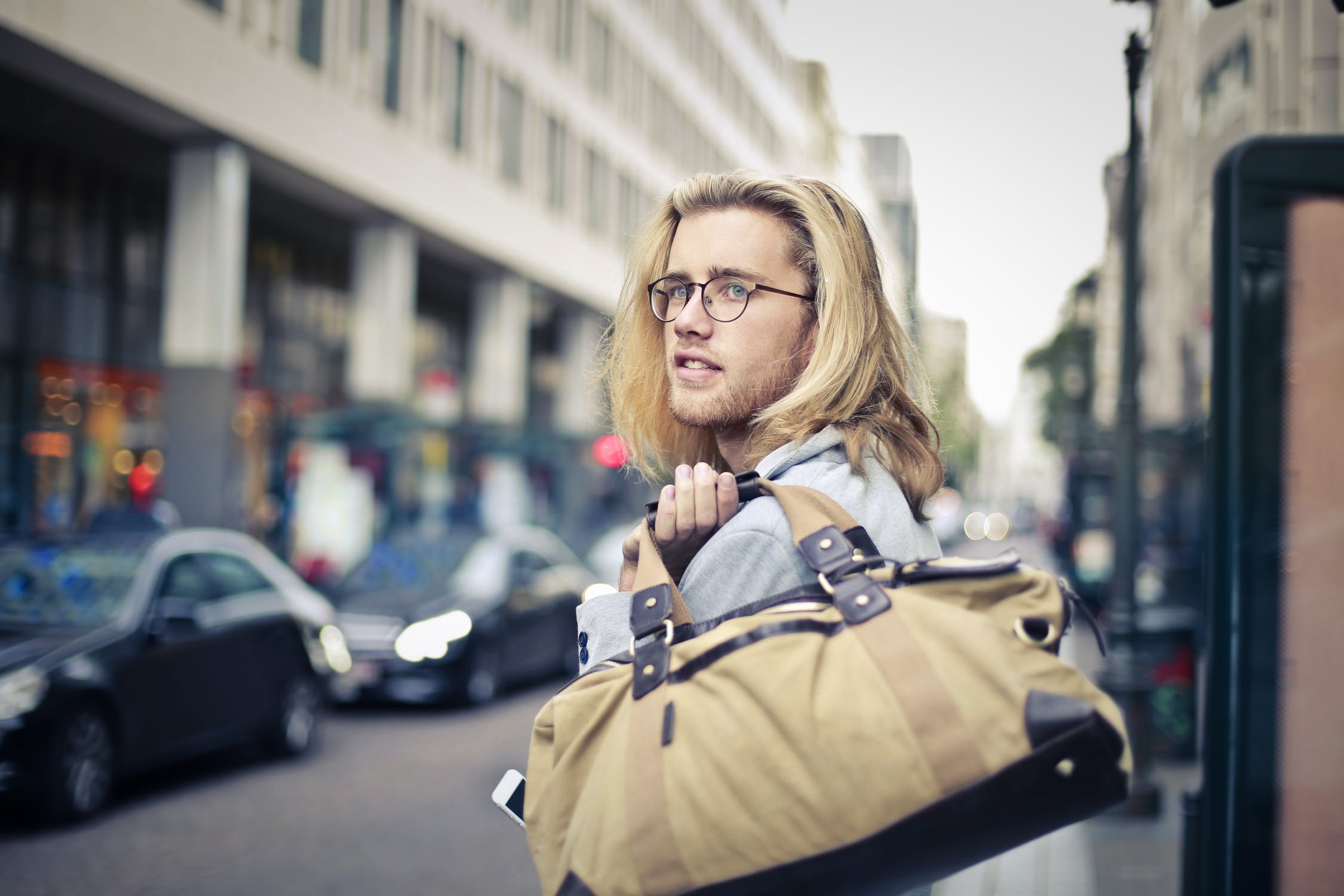 The man wears over his shoulder VINTAGE WEEKENDER BAG "ANTIQUUS"