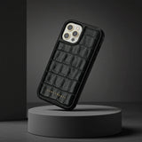 Black crocodile-patterned phone case on a gray background