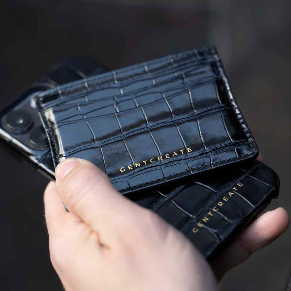 Kartenetui aus Glänzendem Leder  Mann hält schwarzen Leder Kartenhalter und iPhone Lederhülle von Gentcreate