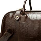 Brown leather bag with textured surface and visible stitching on a white background