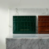 Two green and brown crocodile-textured card holders on a marble surface with 'GENTCREATE' branding.