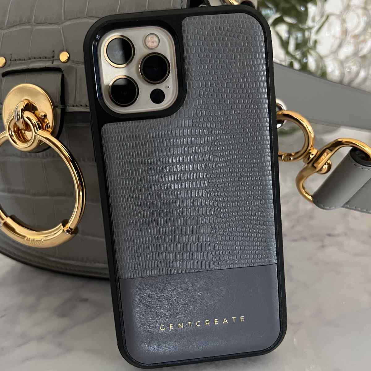 A Gray Top Grain iPhone Leather Case by Gentcreate leaning on a Calfskin Leather Gray Women Bag A Gray Top Grain iPhone Leather Case by Gentcreate leaning on a Calfskin Leather Gray Women Bag