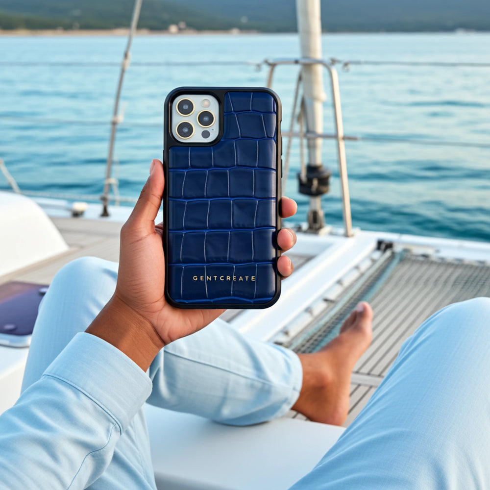 Person holding a blue phone case with a crocodile pattern on a boat with ocean view