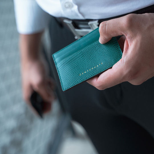 The man holds a green lizard leather cardholder by Gentcreate.