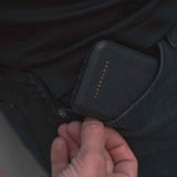 A man takes out a Saffiano pattern leather case from his pocket by Gentcreate