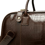Brown leather bag with textured surface and visible stitching on a white background