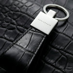 Keychain with 'GENTCREATE' branding on a black alligator leather surface