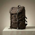 Brown backpack with leather straps on a neutral background