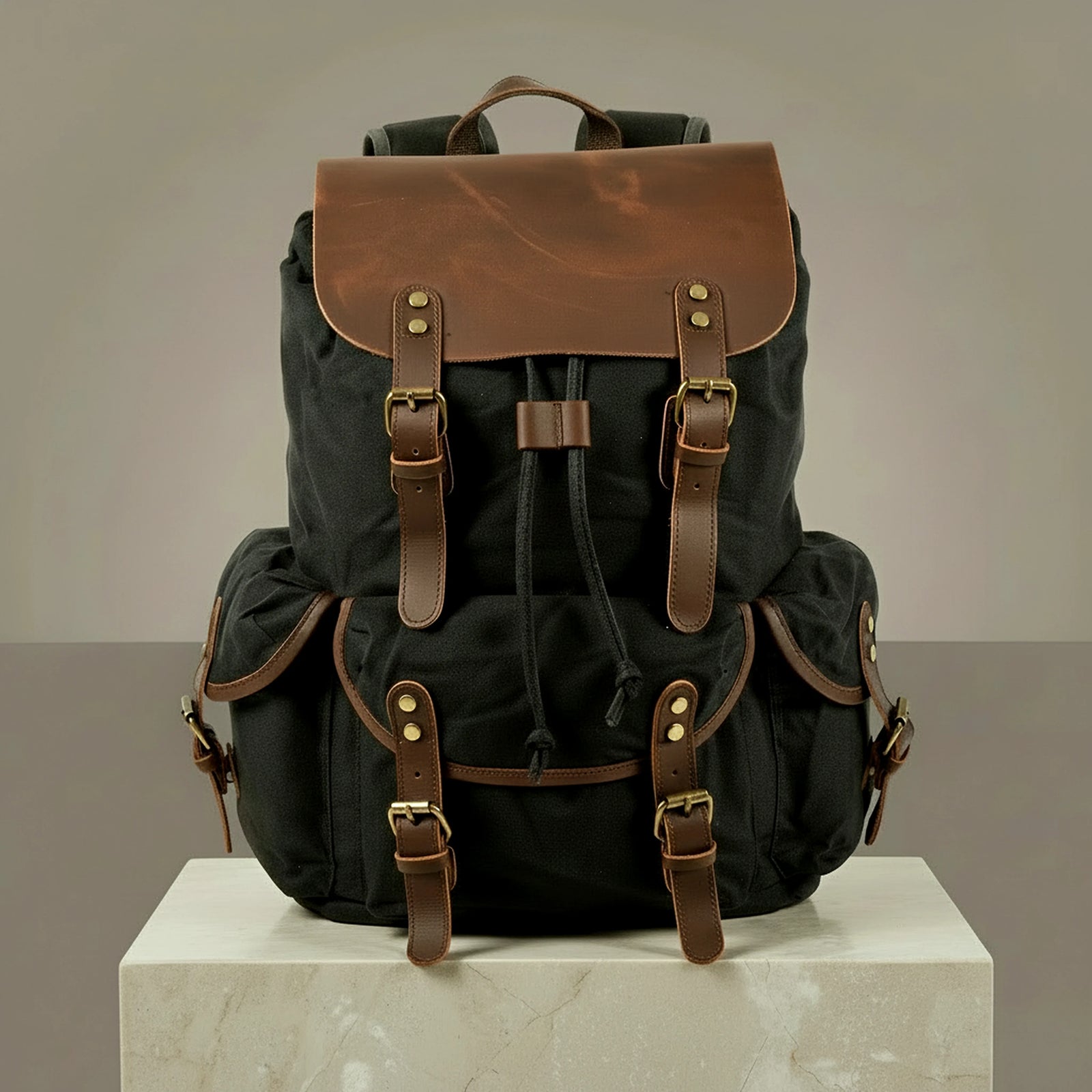 Black canvas and leather backpack with brown leather straps on a neutral background