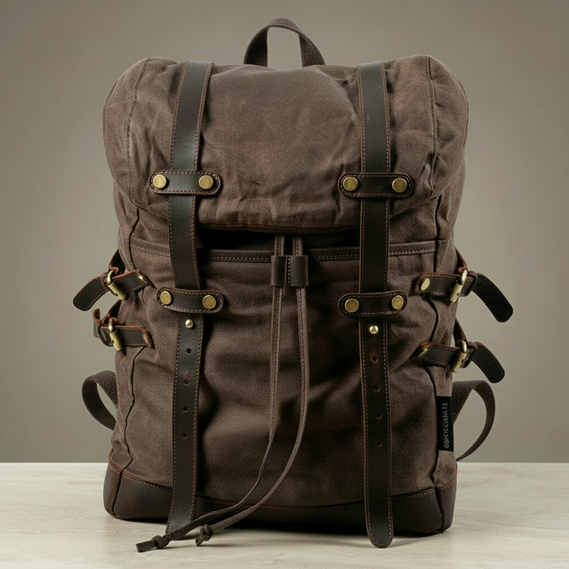 Brown backpack with leather straps on a neutral background