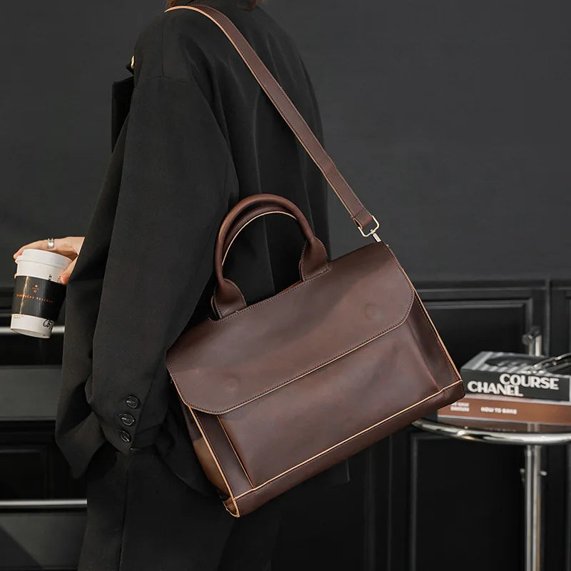A man is carrying a premium leather brown messenger bag over his shoulder by the luxury fashion brand Gentcreate.