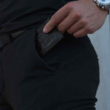 The man is putting a black leather card holder by Gentcreate into his pants pocket.