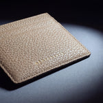 Close-up of the gold GENTCREATE stamp pressed into a beige pebble leather card holder