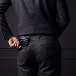 Man sliding a black crocodile-embossed leather bifold wallet by GENTCREATE into his back trouser pocket