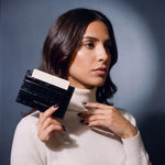 Woman holding a slim black crocodile-embossed leather card holder by GENTCREATE between two fingers