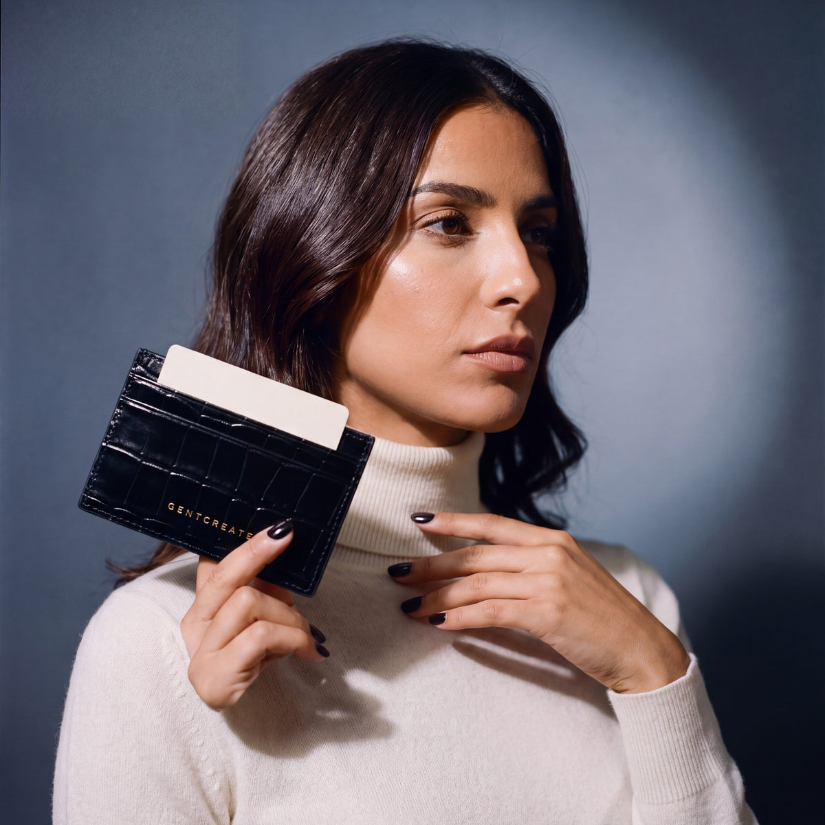 Woman holding a slim black crocodile-embossed leather card holder by GENTCREATE between two fingers