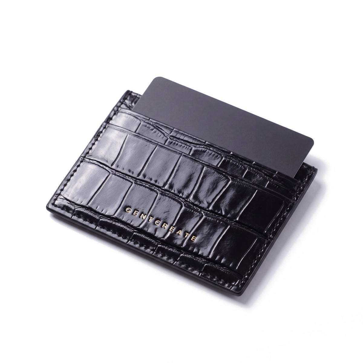 Black crocodile-embossed leather card holder by GENTCREATE standing with a card, on white
