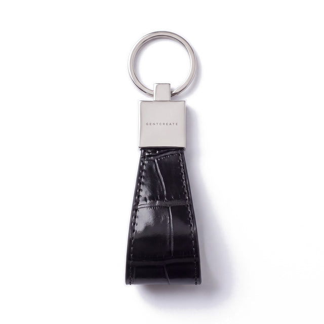 Black crocodile-embossed leather keychain by GENTCREATE lying flat on white: split ring, polished clasp and stitched loop