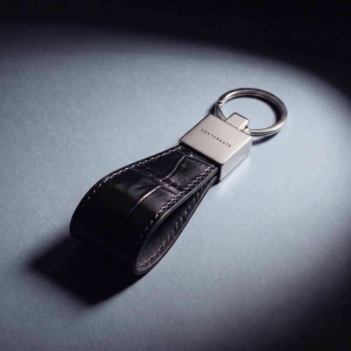 Close-up of the steel clasp of a black crocodile-embossed leather keychain by GENTCREATE
