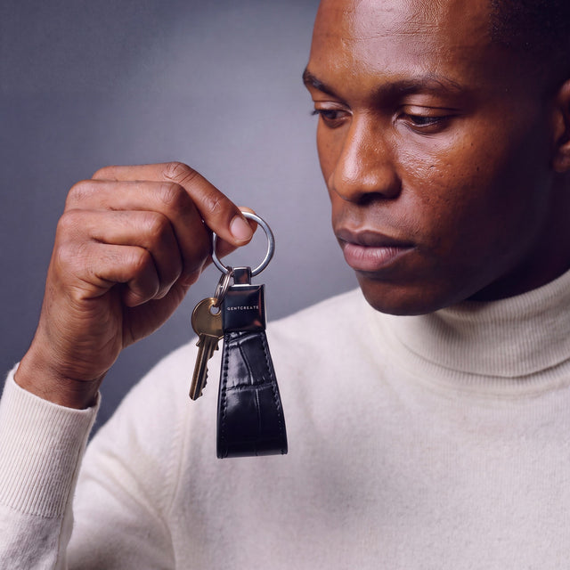 Man holding a black crocodile-embossed leather keychain by GENTCREATE with house keys