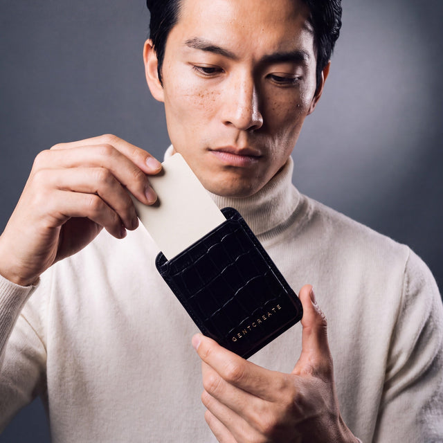 Man taking a card out of a black crocodile-embossed leather magnetic card wallet by GENTCREATE