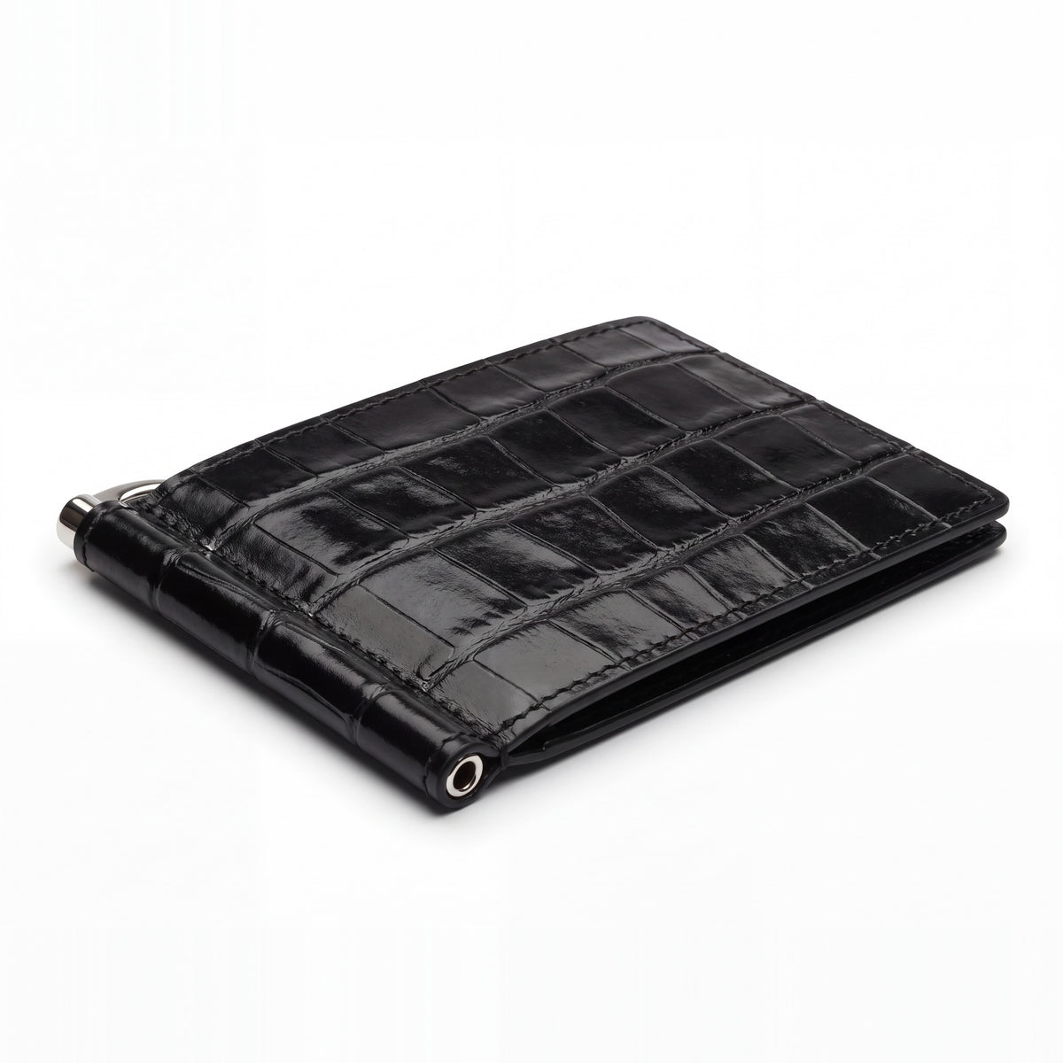 Closed black glossy crocodile-embossed leather money clip wallet by GENTCREATE with its silver clip, on white
