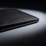 Close-up of the painted edge and stitching of a black lizard-embossed leather bifold wallet by GENTCREATE