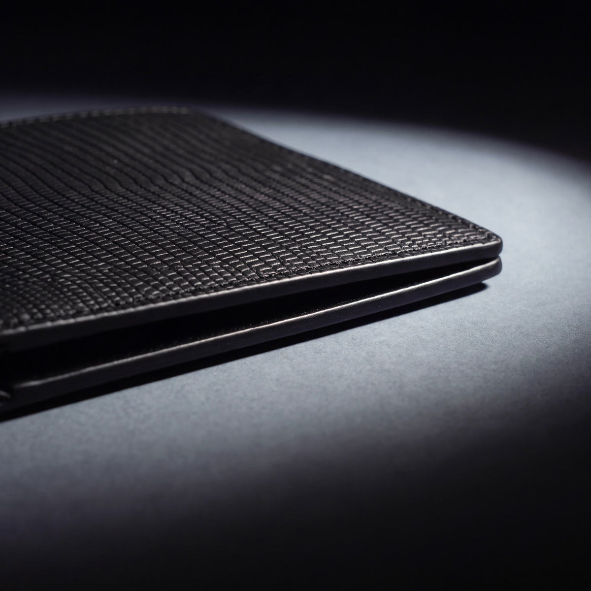 Close-up of the painted edge and stitching of a black lizard-embossed leather bifold wallet by GENTCREATE