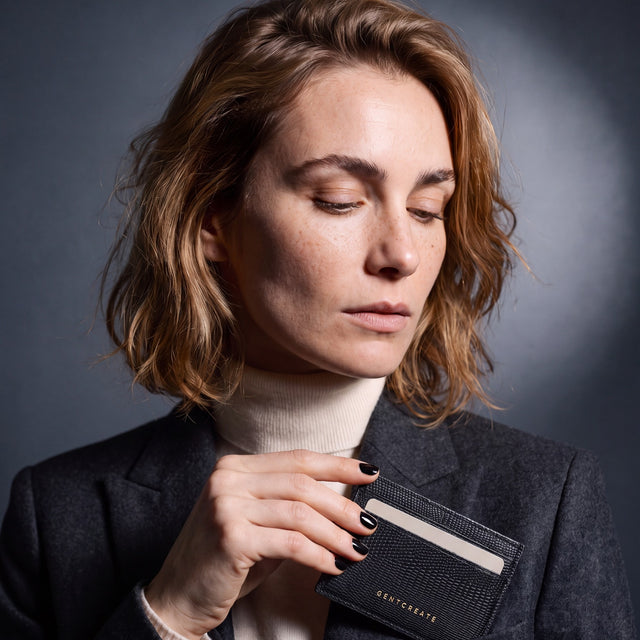 Woman slipping a black lizard leather card holder by GENTCREATE into a blazer chest pocket