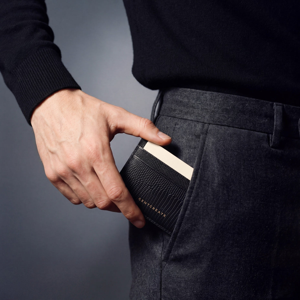Man sliding a black lizard-embossed leather card holder by GENTCREATE into his trouser front pocket