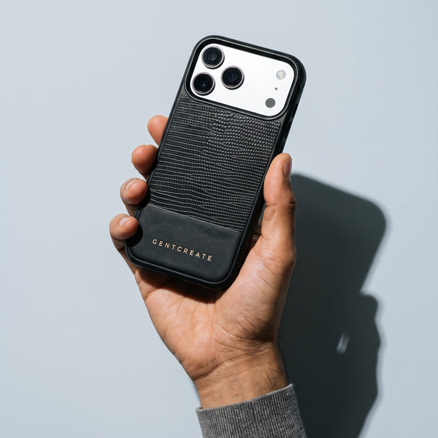 Hand holding a black lizard-embossed leather iPhone 18 Pro Max case by GENTCREATE against pale grey