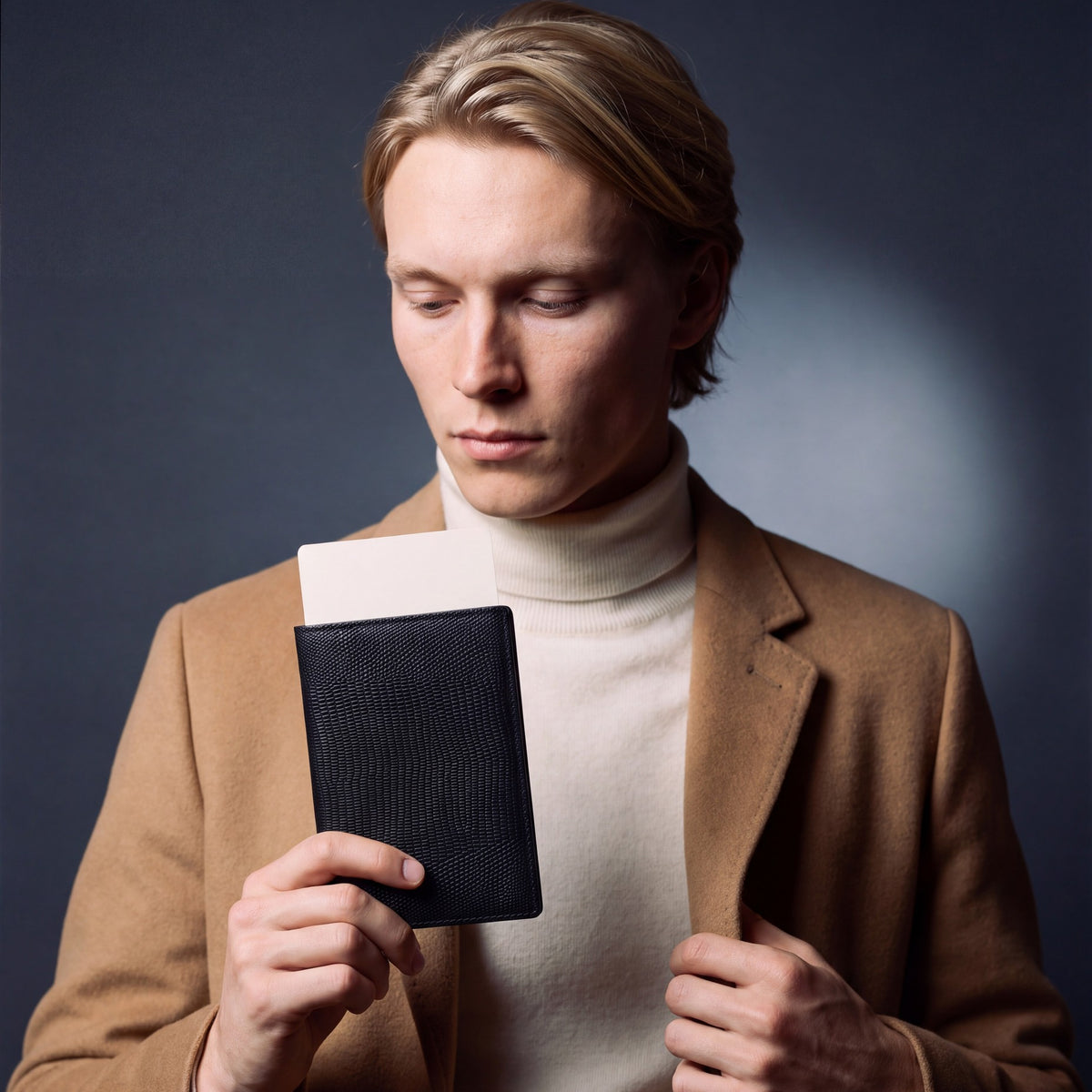 Man holding a black lizard-embossed leather passport holder by GENTCREATE with a blank card tucked in