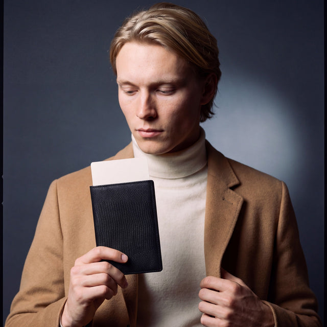 Man holding a black lizard leather passport holder by GENTCREATE with a blank card tucked in