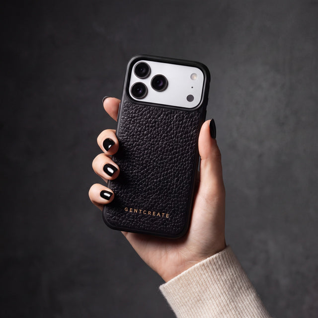 Hand with black nails holding a black pebble-grain calfskin iPhone 18 Pro Max case by GENTCREATE