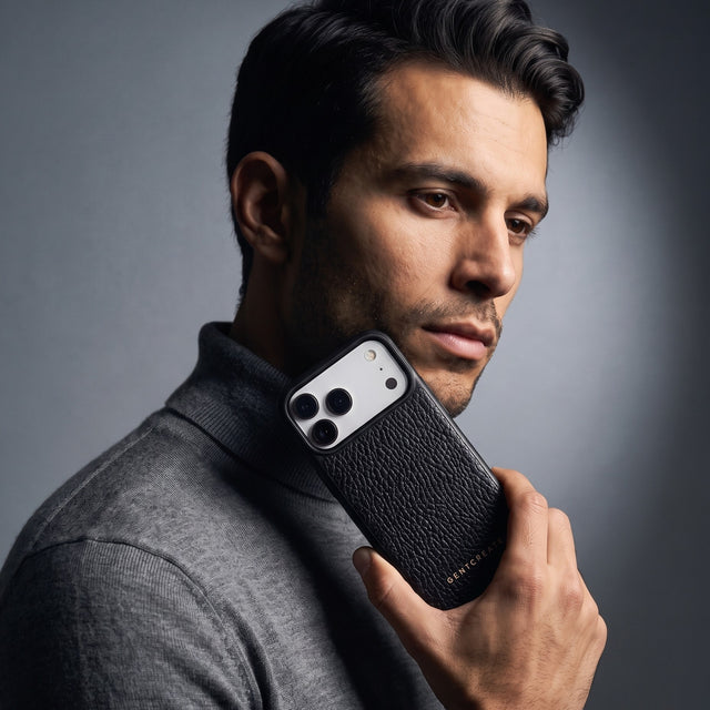 Man holding a black pebble-grain leather iPhone 18 Pro Max case by GENTCREATE beside his face