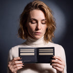 Woman opening a black Saffiano leather bifold wallet by GENTCREATE to show the card slots