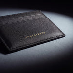 Close-up of the gold GENTCREATE stamp pressed into a black Saffiano leather card holder