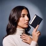 Woman holding a slim black Saffiano leather card holder by GENTCREATE between two fingers