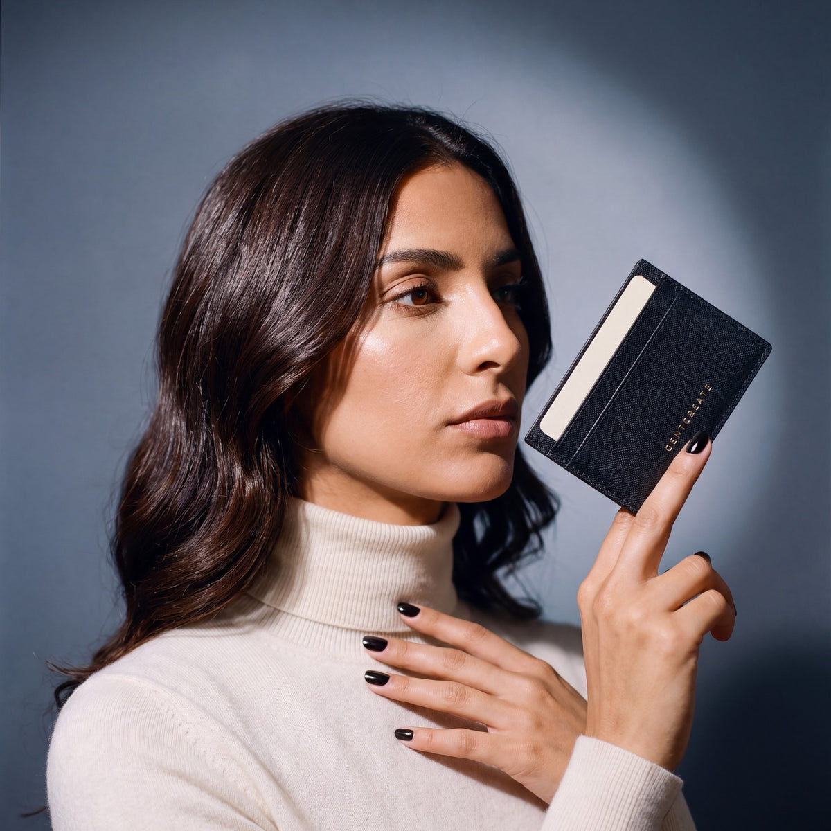Woman holding a slim black Saffiano leather card holder by GENTCREATE between two fingers