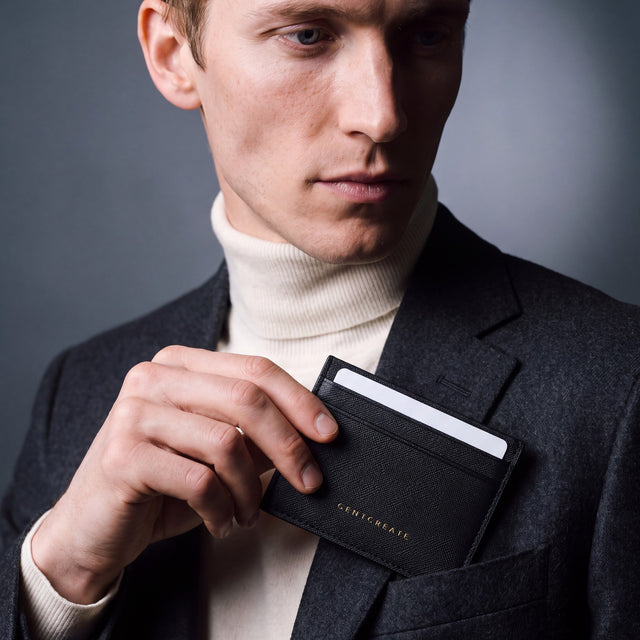Man slipping a black Saffiano leather card holder by GENTCREATE into a blazer chest pocket