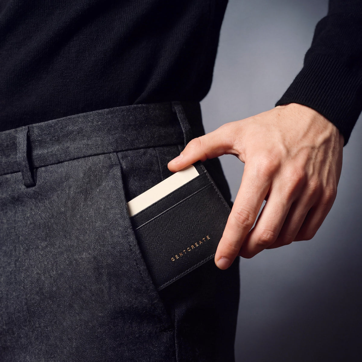 Man sliding a black Saffiano leather card holder by GENTCREATE into his trouser front pocket