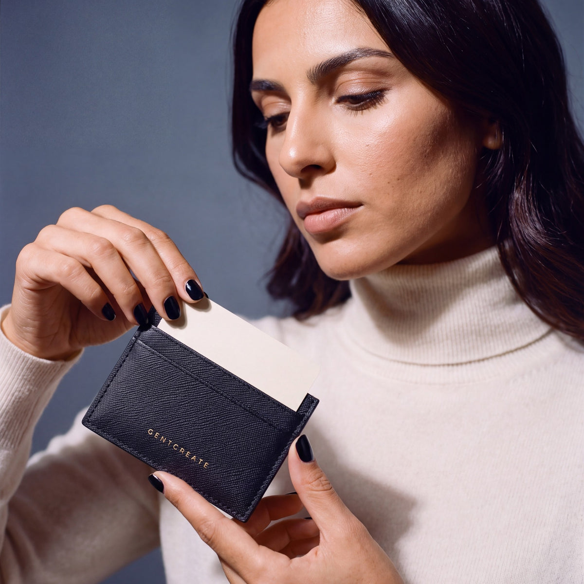 Woman holding a slim black Saffiano leather card holder by GENTCREATE and drawing out a card