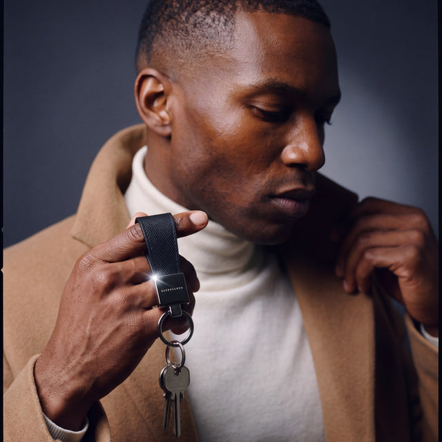 Man heading out with house keys on a black Saffiano leather keychain by GENTCREATE