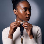 Woman holding up a black Saffiano leather keychain by GENTCREATE with house keys