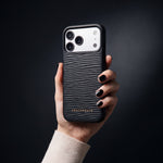 يد بأظافر سوداء تمسك جرابًا أسود لهاتف iPhone 18 Pro Max من جلد عجل بنقش موجي بارز من GENTCREATE