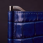 Close-up of the silver end cap and money clip on a blue glossy crocodile-embossed leather wallet by GENTCREATE