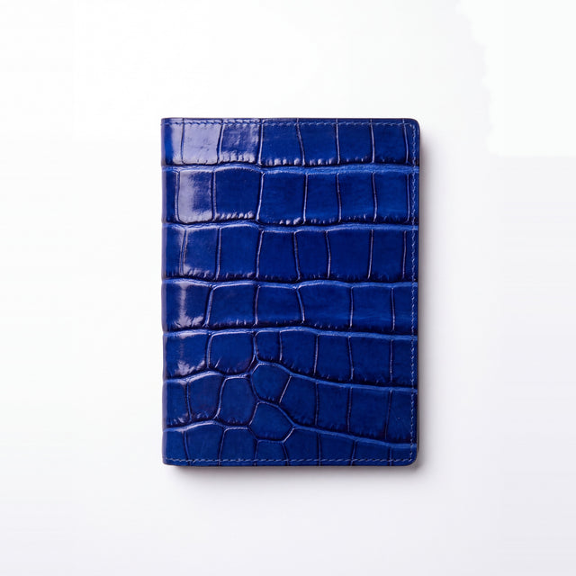 Porta-passaporte da GENTCREATE em pele azul brilhante gravada efeito croco, fechado, visto de cima, em fundo branco